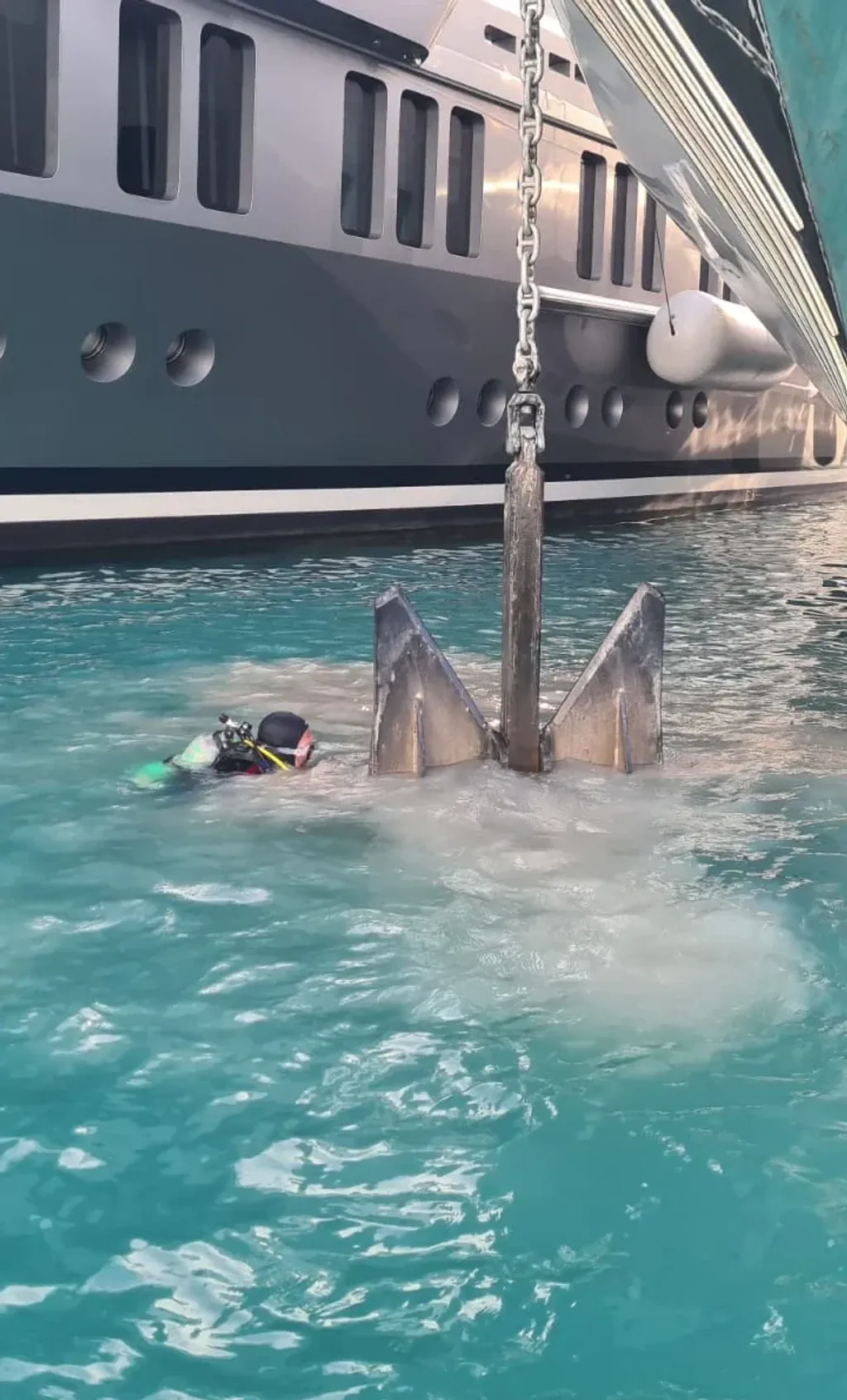 A diver at a yacht anchor beneath a superyacht in Sint Maarten
