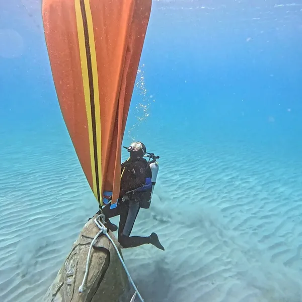 Cylipso Diving diver working beneath a large orange lift bag over a mooring block